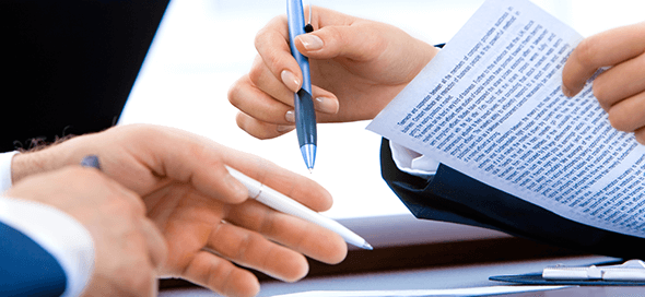 Two people preparing to sign paperwork