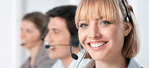 Woman with her coworkers, all wearing headsets