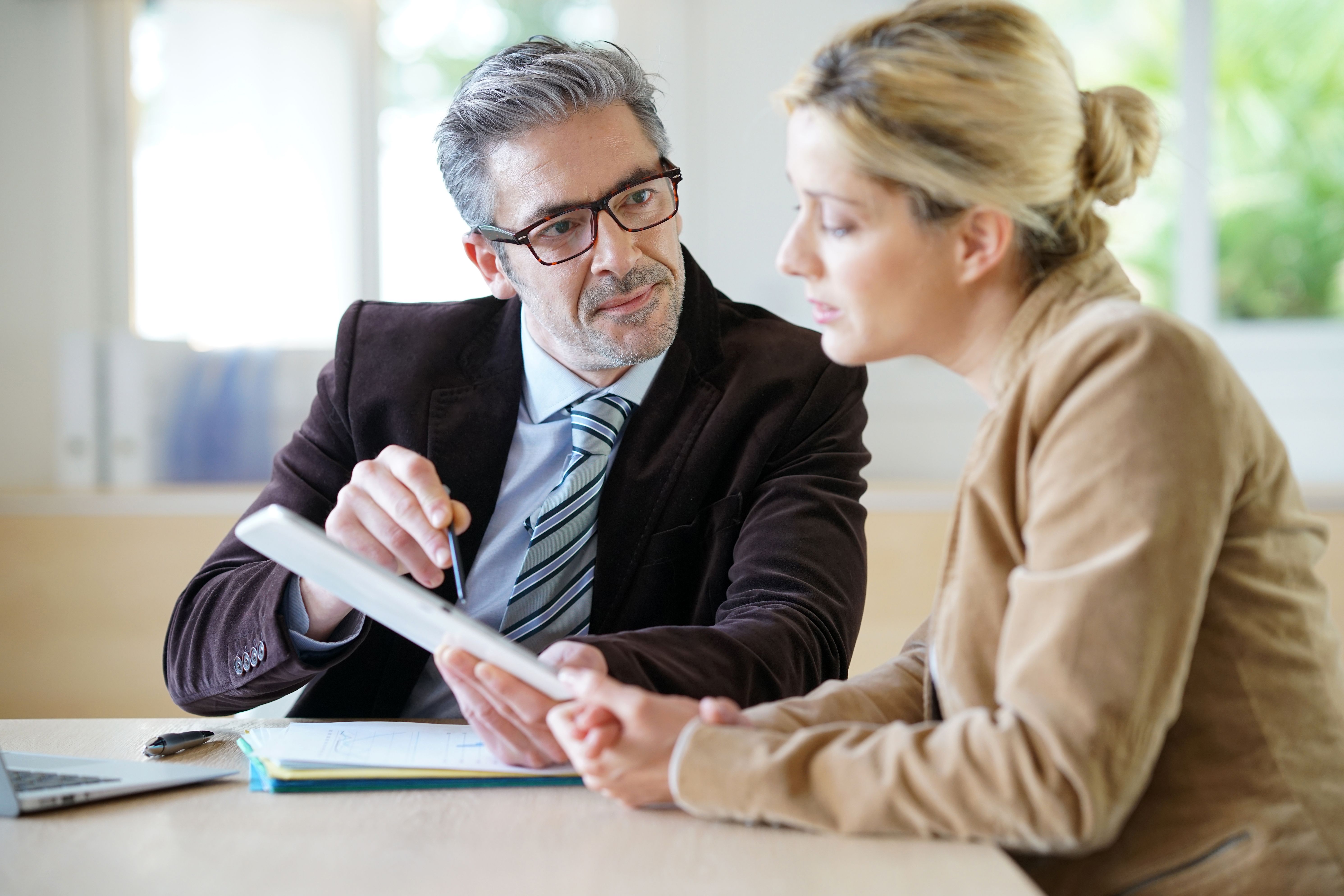 Man explaining legal documents to his female client