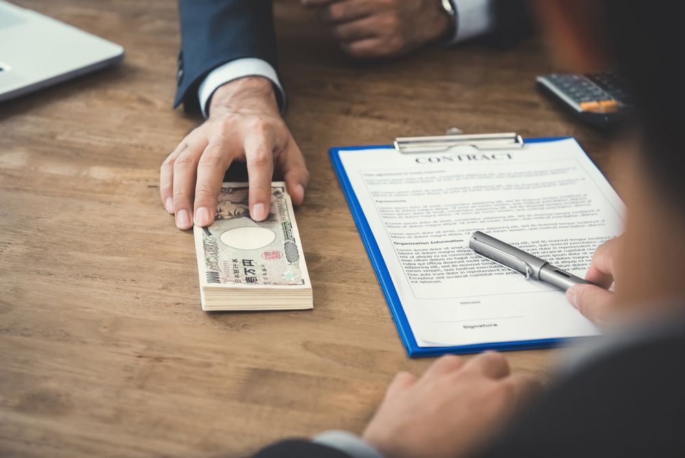 Someone exchanging money during the signing of a contract